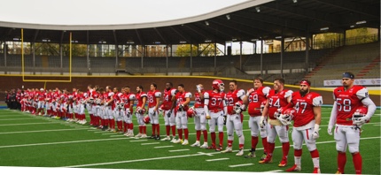 American Football Player standing ready for game on field.